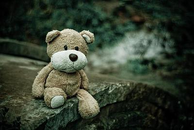 Lost teddy bear on a stone wall