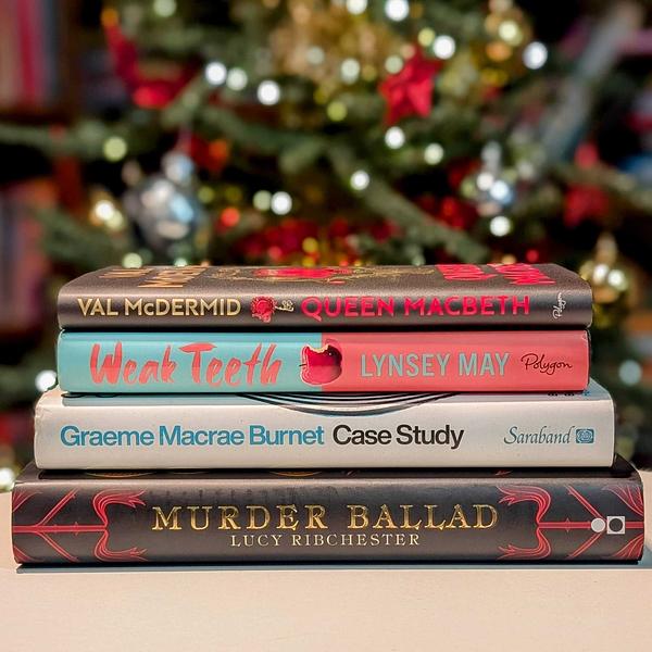 Pile of four books - Queen Macbeth, Weak Teeth, Case Study and Murder Ballad - in front of a Christmas tree